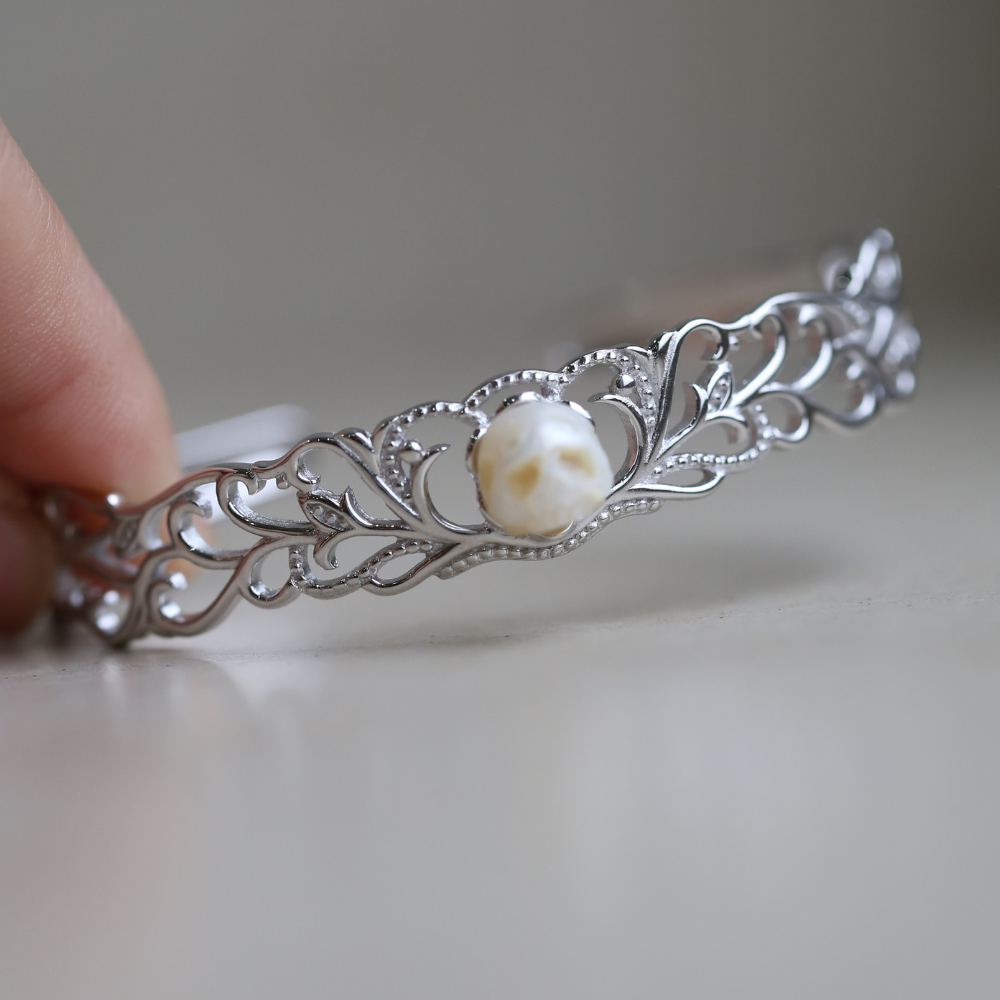 Armreif aus Sterlingsilber mit geschnitztem Perlenschädel